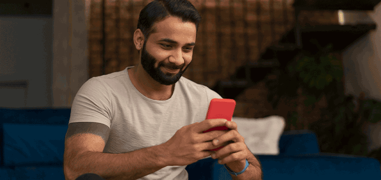 Um homem sentado olhando para um celular