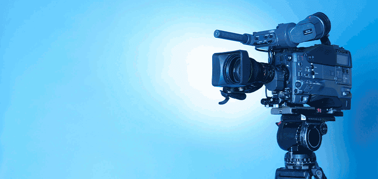 Uma câmera em um tripé com fundo azul
