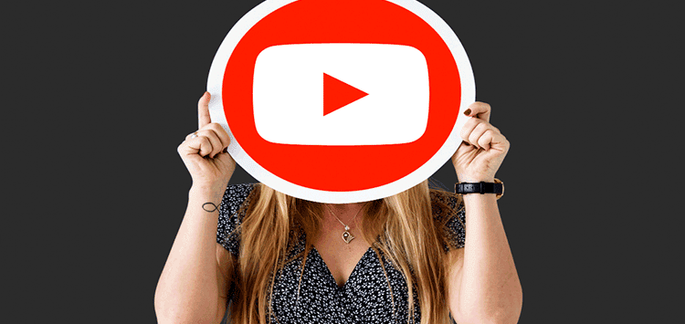 Uma mulher segurando uma placa com o símbolo do Youtube
