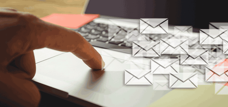 Uma pessoa está digitando em um teclado de laptop com vários ícones de email
