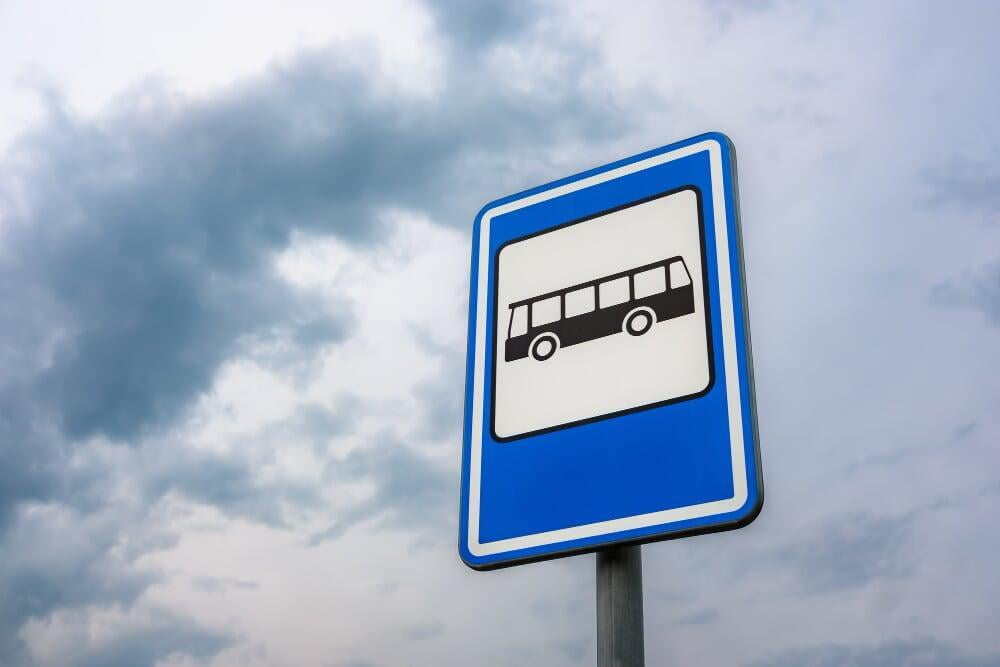 Uma placa azul e branca com um ônibus