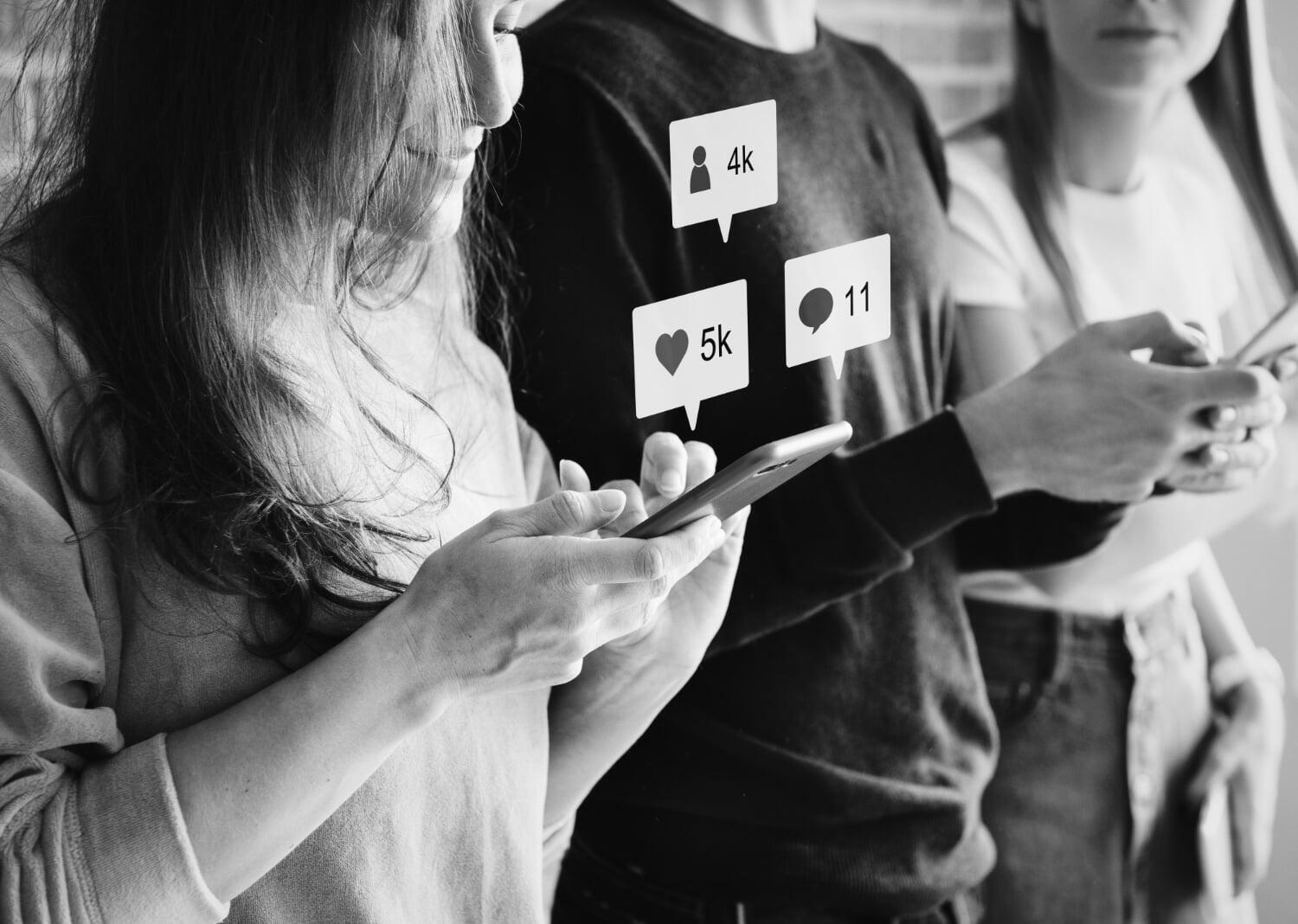 Três pessoas mexendo no celular com ícones de seguidores, curtidas e comentários flutuando