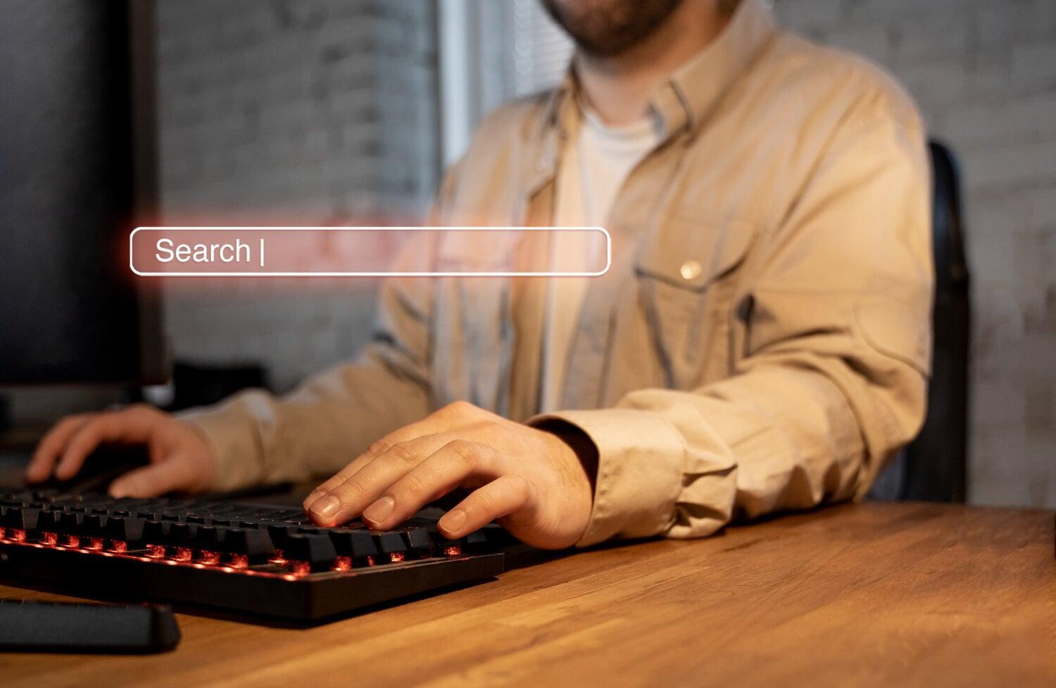 Homem digitando em teclado com barra de pesquisa virtual em destaque na tela