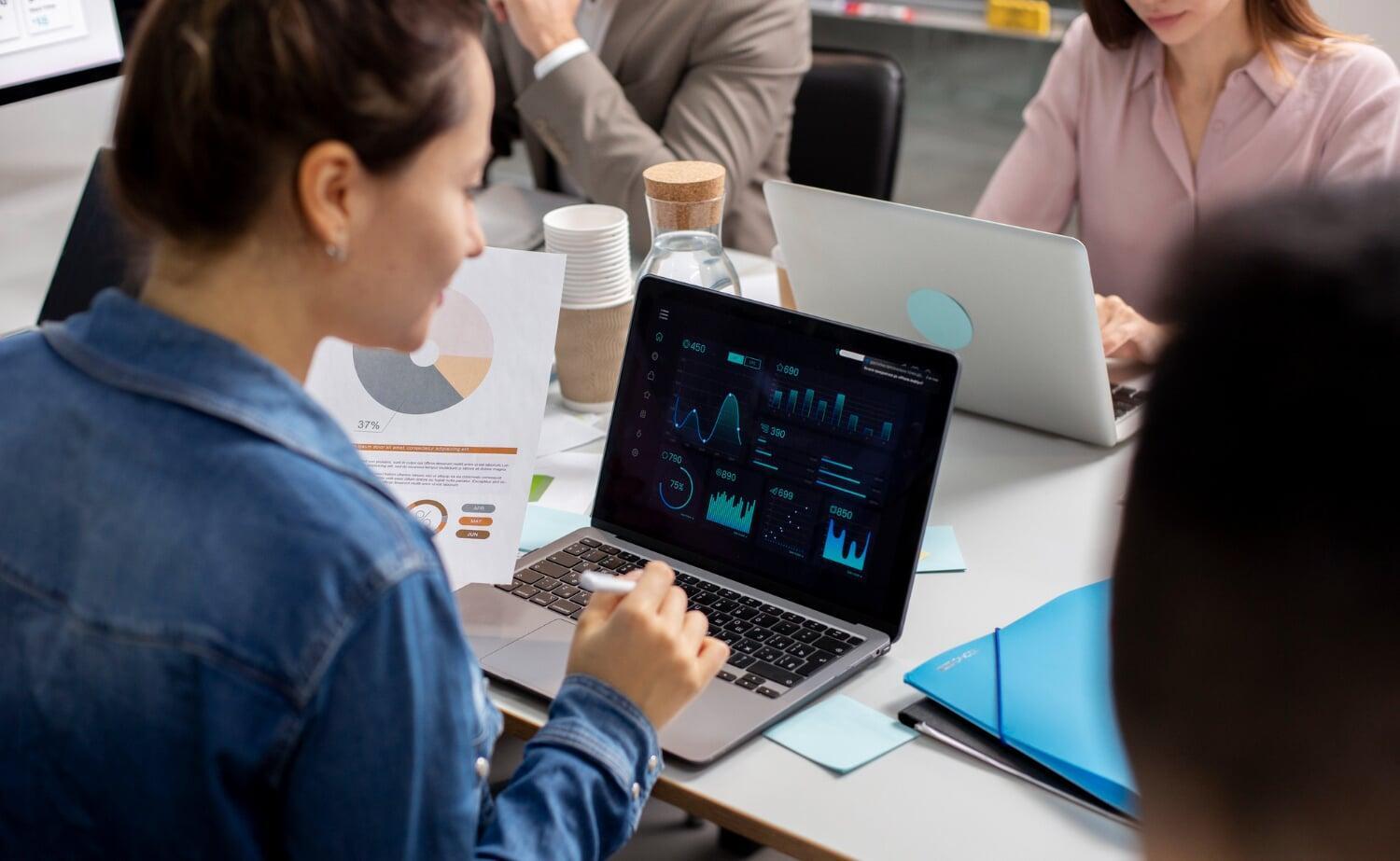 Mulher analisando gráficos e dados de marketing digital em tela de notebook