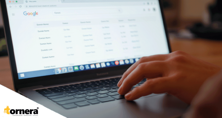 Mãos digitando em notebook com tela aberta em ferramenta de busca por domínios